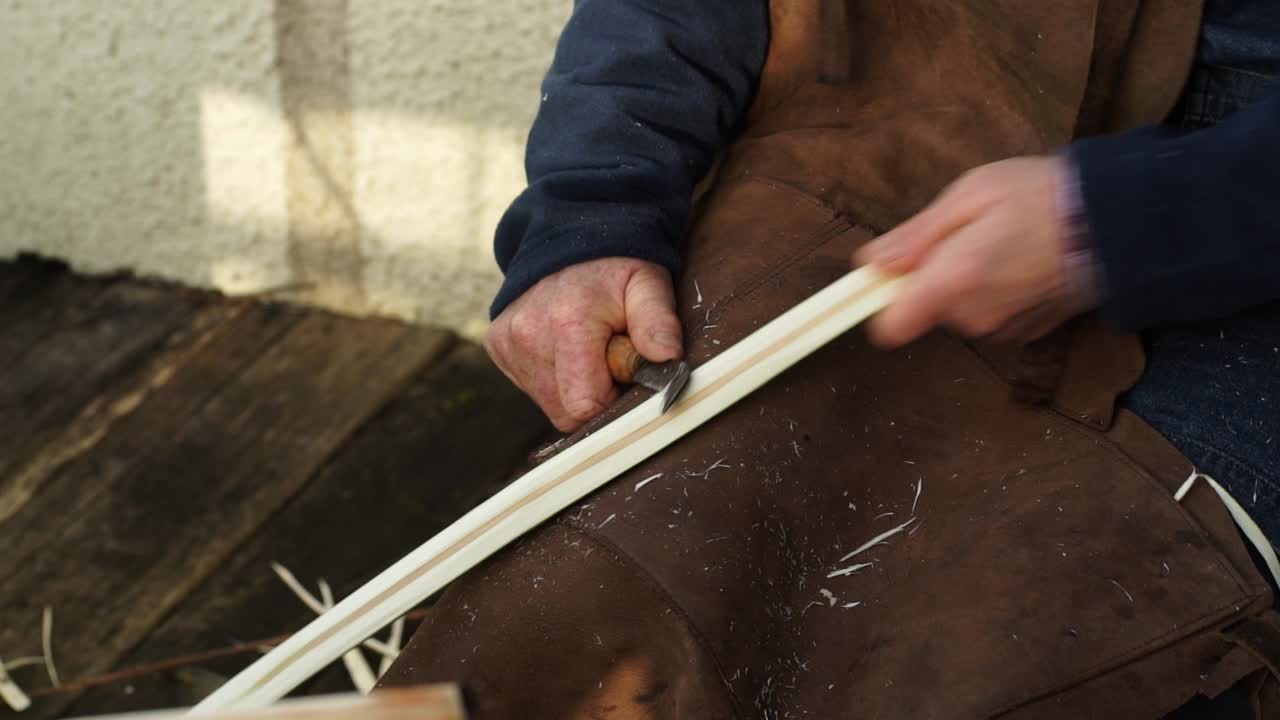 un cestero cortando varillas de madera para hacer cestas galesas