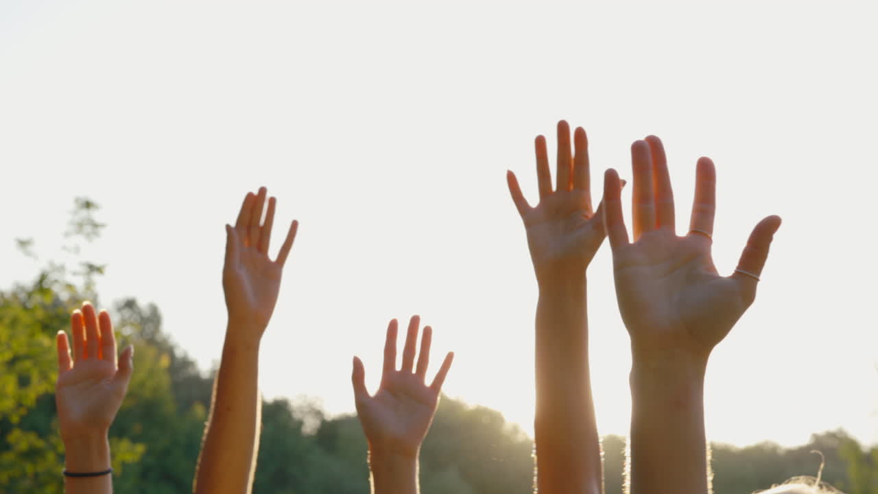 Hands raised in sunlight