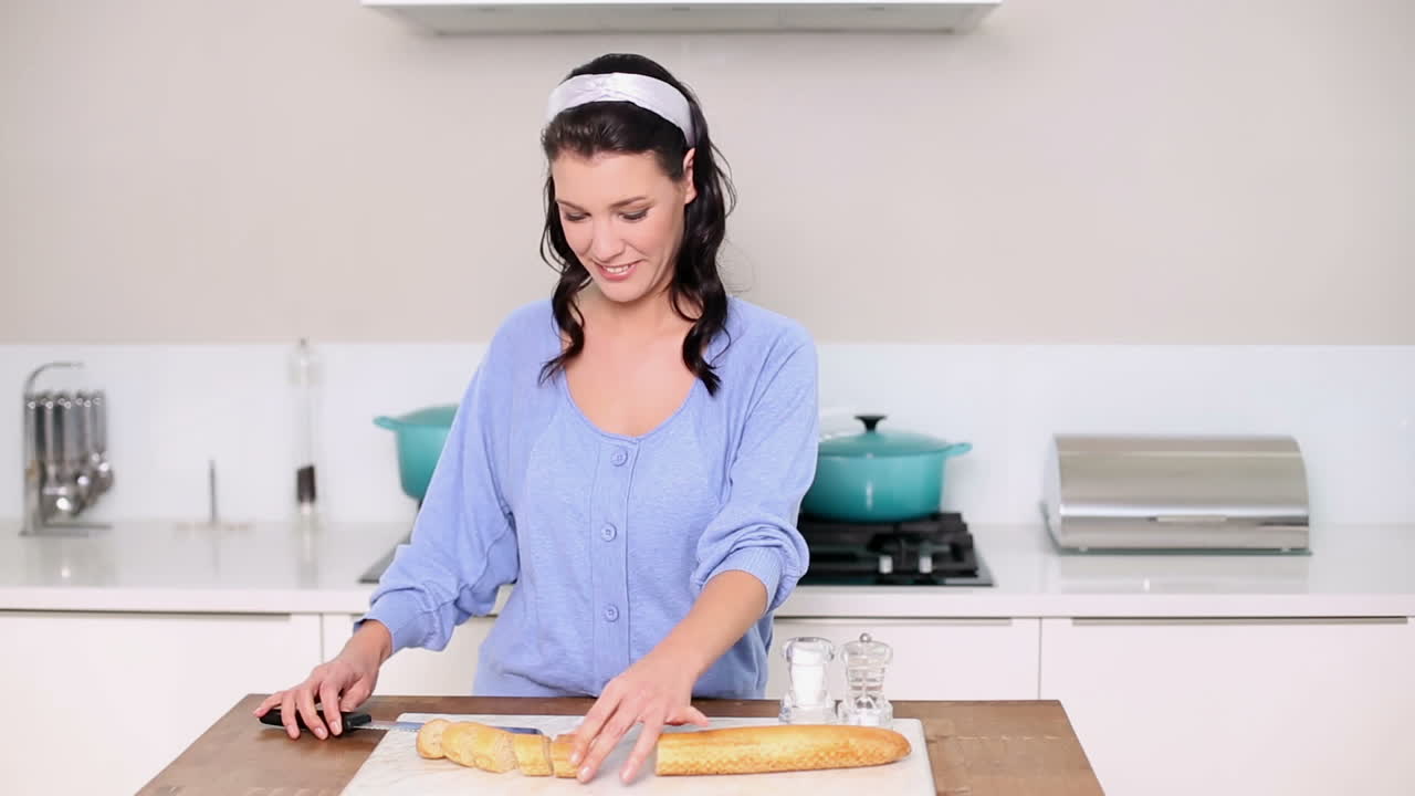 una hermosa morena cortando una baguette
