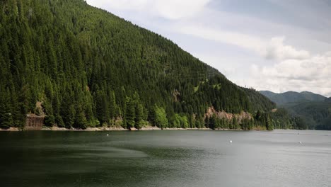 Scenic-Lake-Surrounded-With-Green-Lush-Mountains---panning-shot