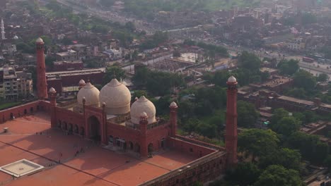 cinematic aerial view above badshahi mosque, lahore, pakistan. red sandstone landmark