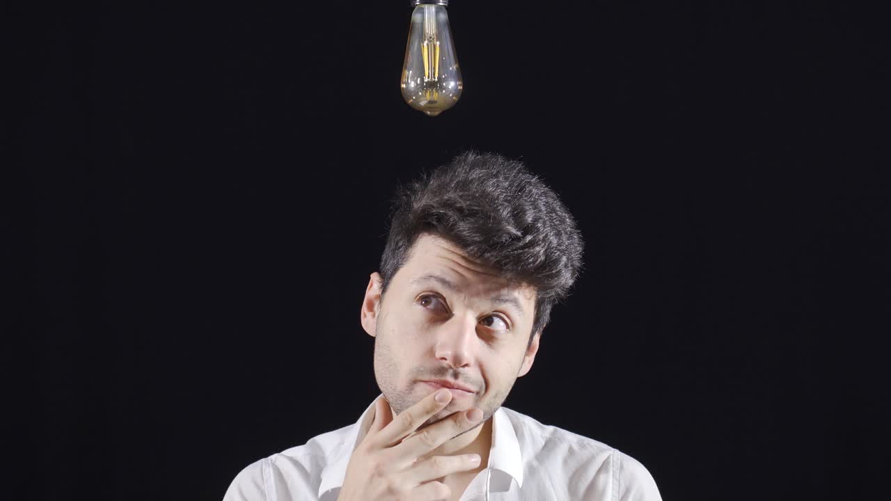 남자는 생각하고, 아이디어가 떠오르면, 그의 머리 위의 램프가 켜집니다.