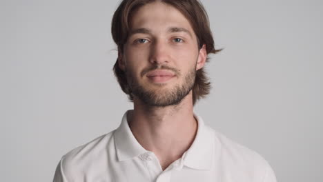 Caucasian-confident-man-in-front-of-camera-on-gray-background.