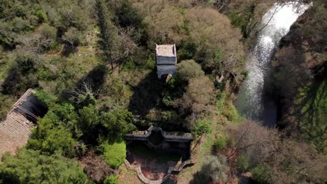 Descending-aerial-tilting-shot-of-a-broken-tower-and-building-in-the-countryside-of-France