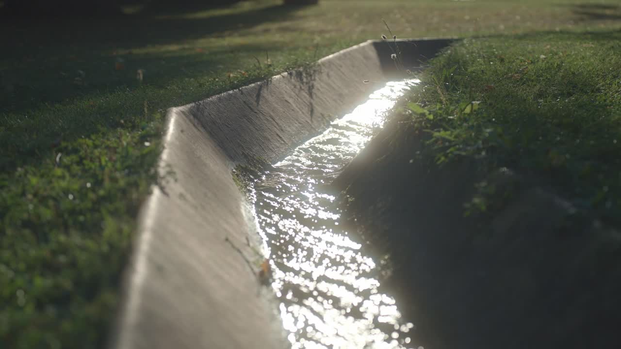 Sunlight reflecting on a water channel in a garden