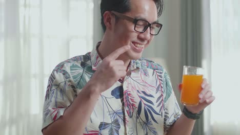 man holding orange juice