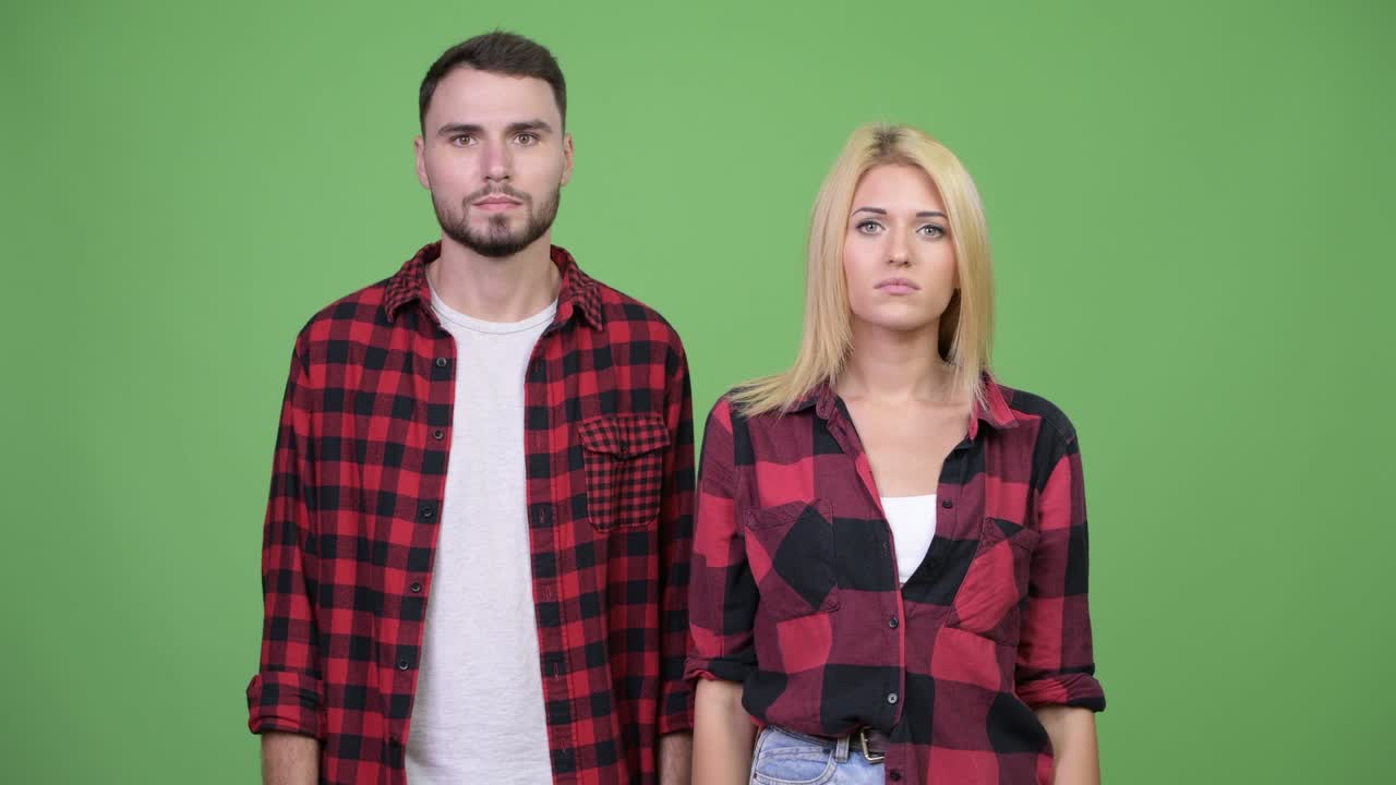 Young couple shrugging shoulders together