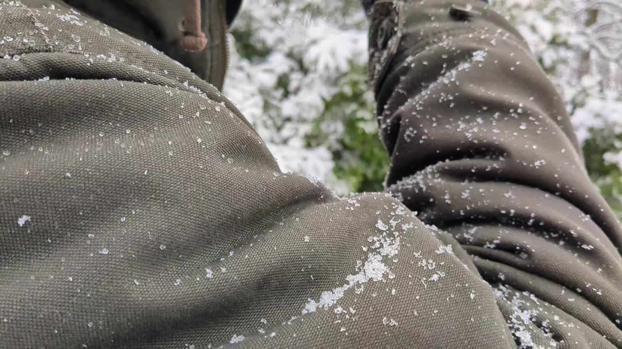 Man drinking hot drink outside in the nature while snowing in winter day