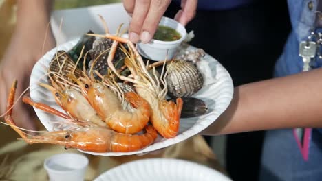 그릴 된 해산물을 파는 아시아 거리 판매자