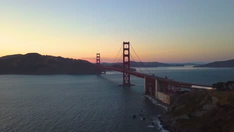 dolly in as a flock of birds fly above golden gate bridge in san francisco - 4k