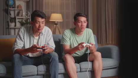 asian friends playing video games at home.