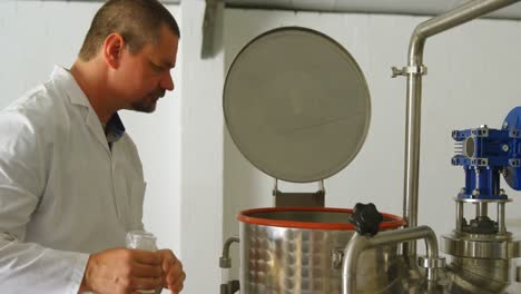 male worker checking distillation tank in factory 4k