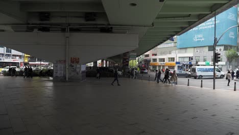 busy city street scene under an overpass