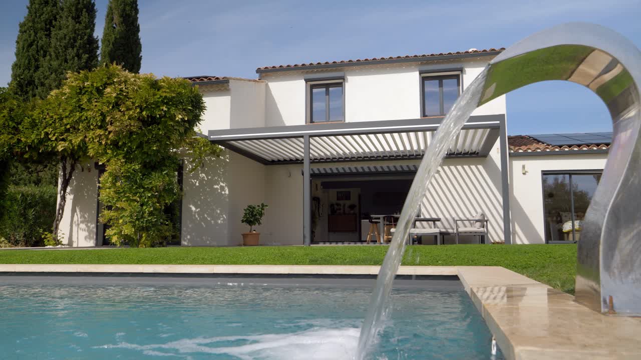 Ripresa orbitante lenta di una grande villa con acqua che riempie la piscina