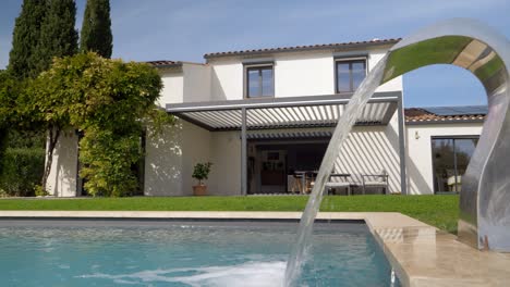 slow orbiting shot of a large villa with water filling the swimming pool