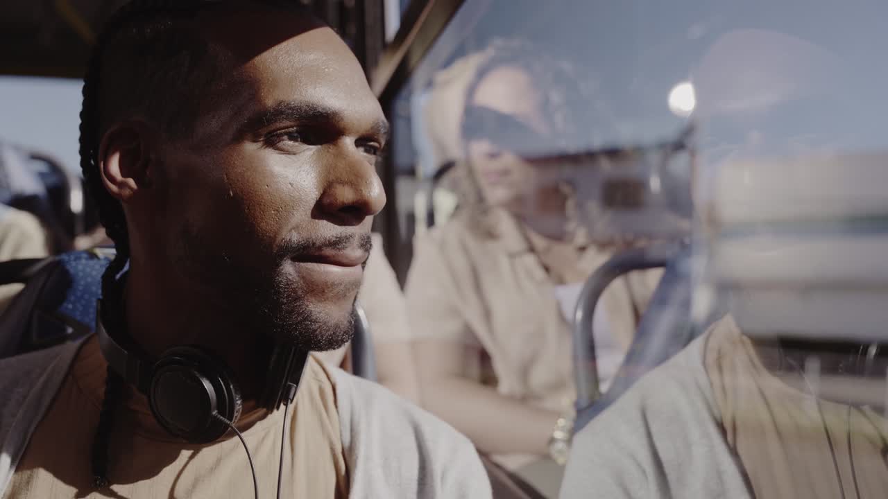 Man looking out the window on a bus