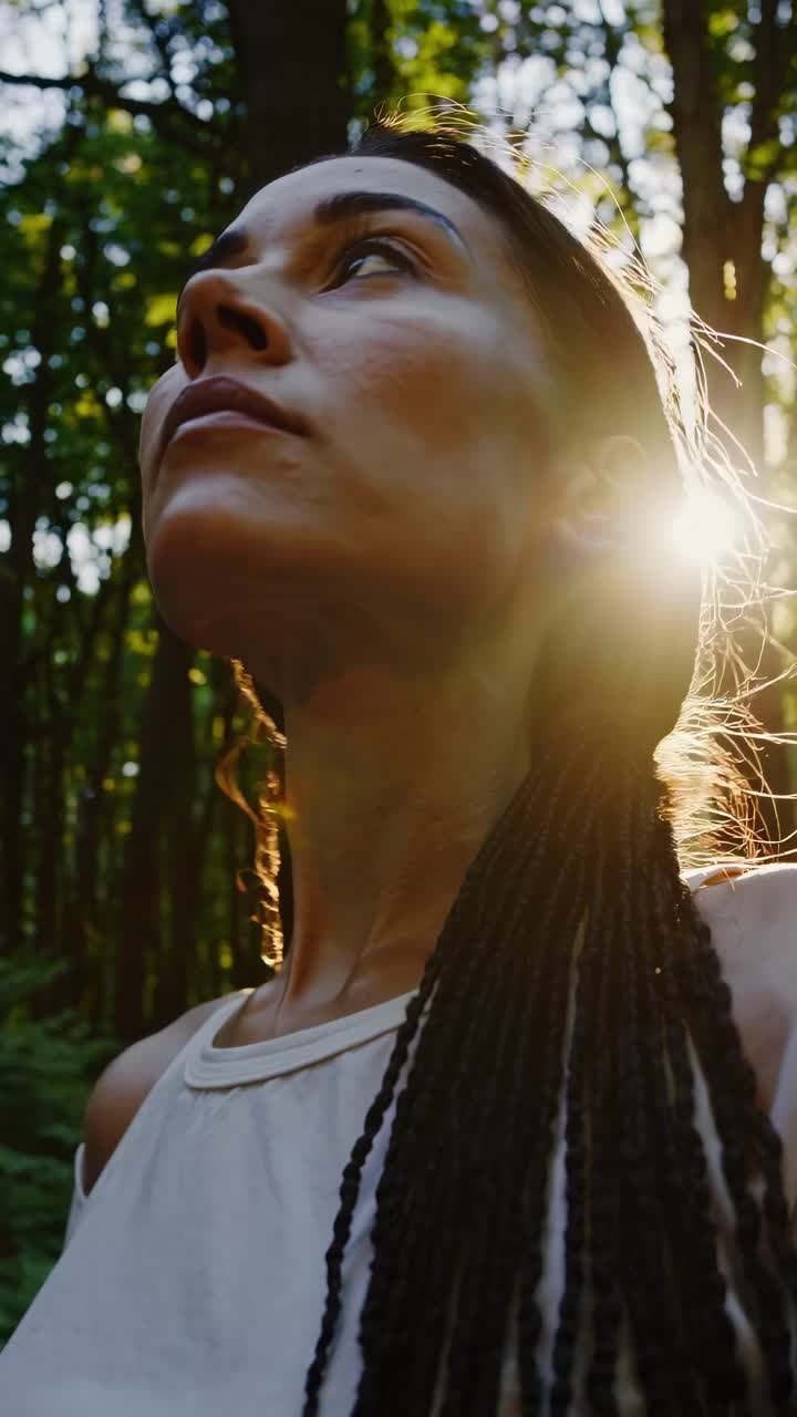 Close-up, low-angle shot of a person looking up, set in a forest