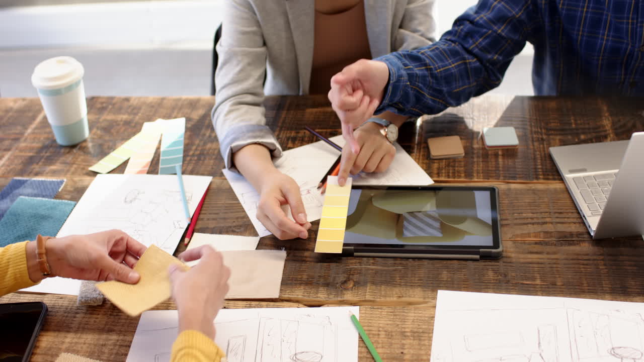 Interior design project, multiracial team using tablet and color swatches, at office