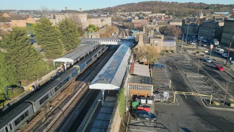 train parked in train station with passengers leaving the train with platform and carpark uk