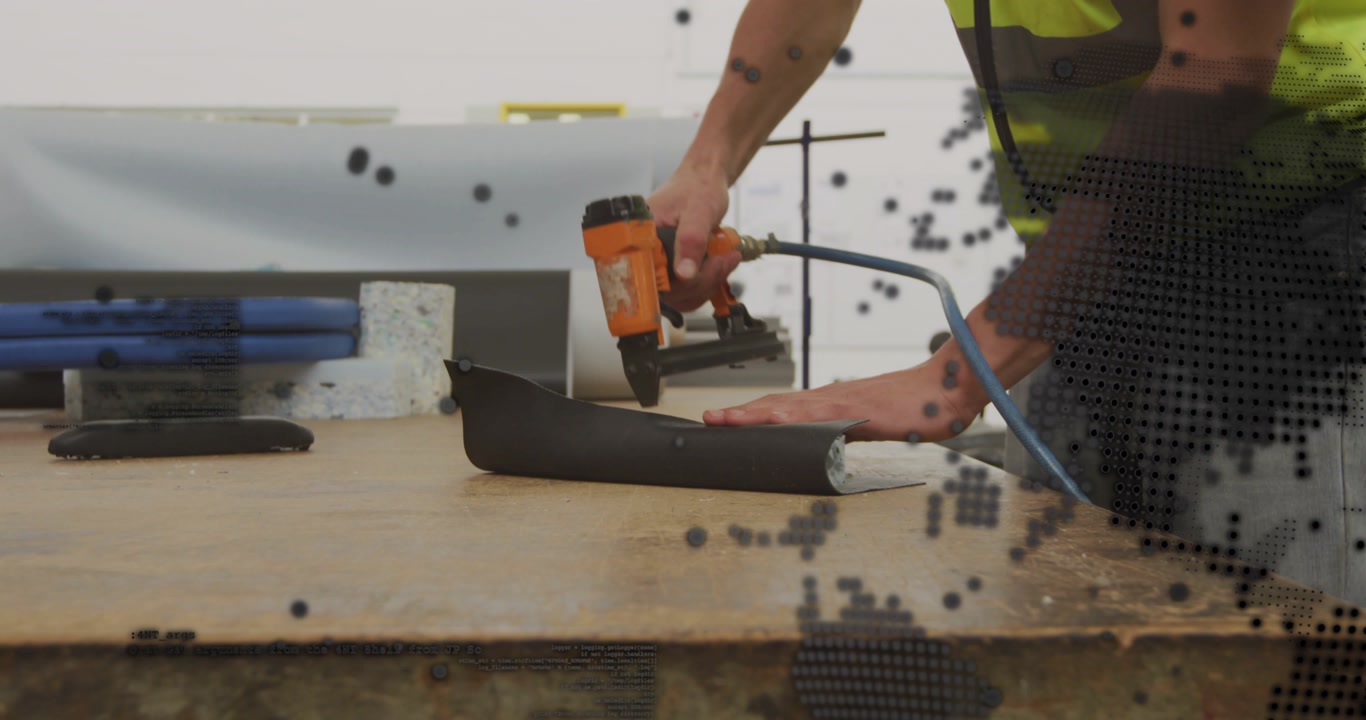 Construction worker reaching for pneumatic nail gun and securing black trim for installation