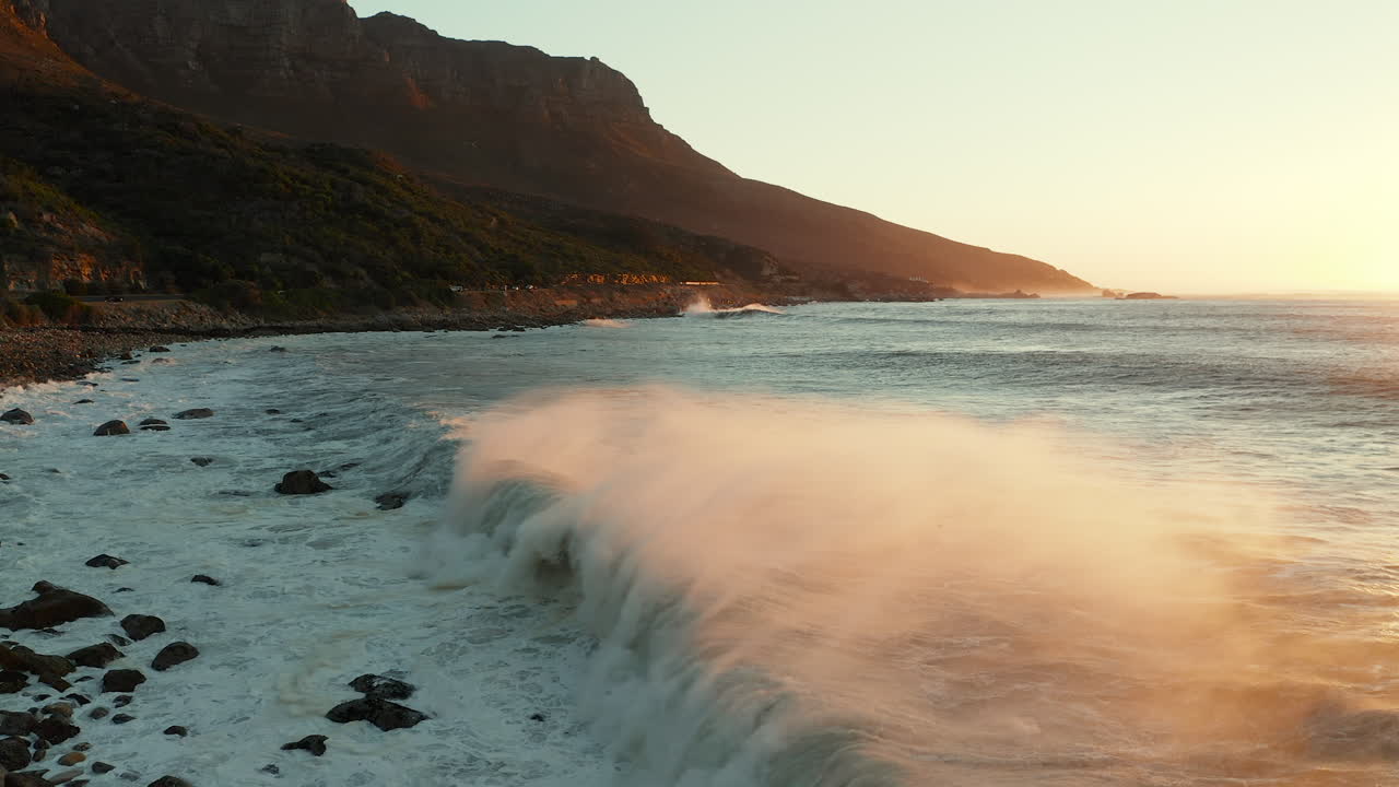 olas escénicas rodando en la playa de marea durante la puesta de sol en la reserva natural de oudekraal en ciudad del cabo, sudáfrica