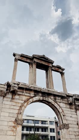 ancient arch of hadrian under cloudy skies in athens