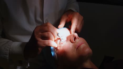 optometrist examining patient eyes with eye test equipment in clinic 4k