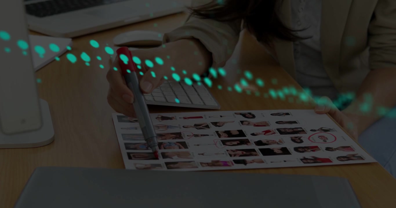 Vertical video: Woman using pen and marking sheet in design, causing teal dots and key digits