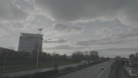 Toma-De-Lapso-De-Tiempo-De-La-Carretera-De-Circunvalación-Alrededor-De-Amberes-Con-Un-Hotel-En-Primer-Plano-Y-Nubes-En-Movimiento-Que-Revelan-El-Registro-Solar