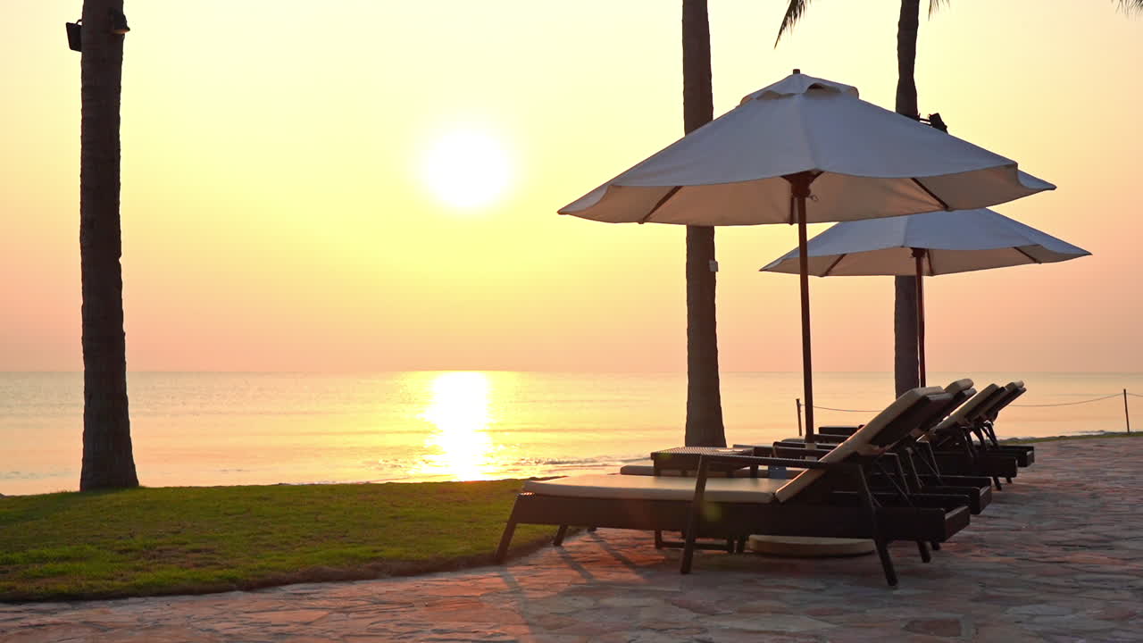 Scenario paradisiaco tropicale, lettini e ombrelloni vuoti con il sole della sera sul mare