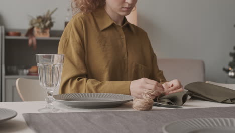 atando una servilleta con hilo en la mesa