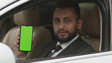 professional driver posing with green-screened smartphone