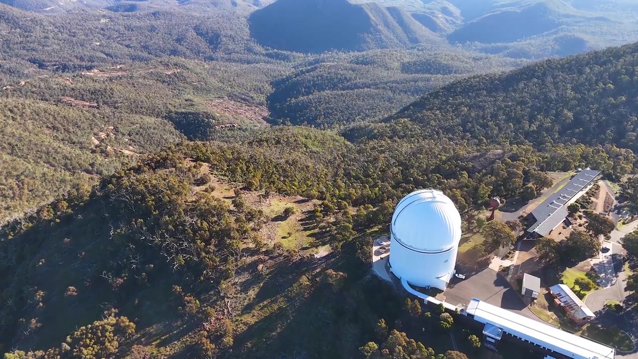 Dronekuva valkoisesta teleskooppikuvusta vuoren huipulla Warrumbungle National Parkissa.