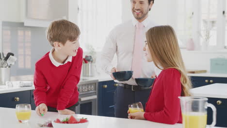 Padre-Vestido-Con-Traje-Sirviendo-El-Desayuno-A-Niños-Con-Uniforme-Escolar-Mientras-Se-Prepara-Para-El-Trabajo