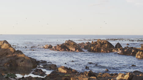 Vista-Del-Paisaje-Con-Rocas-Cerca-Del-Mar-Y-El-Cielo-Azul