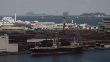 Cargo-Freighter-Ship-At-Dock-In-Port-With-Container-Storage-and-Industry-In-Kokura,-Japan,-Asia