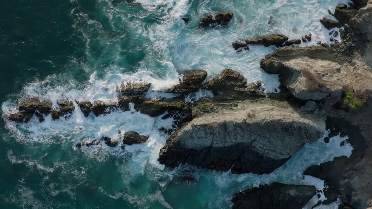 DRONE: SLOW MOTION SHOT OF WAVES CRASHING ON ROCK AT IXTAPA BEACH IN MEXICO