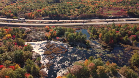 Highway-with-traffic-surrounded-by-vegetation-in-colorful-fall-foliage