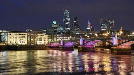 City-of-London-skyline-timelapse-including-22-Bishopsgate,-Walkie-Talkie-and-other-modern-skyscrapers-at-night-with-the-illuminated-Southwark-bridge-in-the-foreground