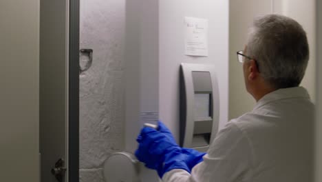 scientist examining blood samples in a laboratory freezer