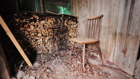 chair stands by wall, chopped firewood in shed rustic stillness, latvian village