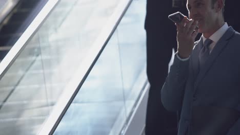 businessman using mobile phone on escalator in a modern office 4k