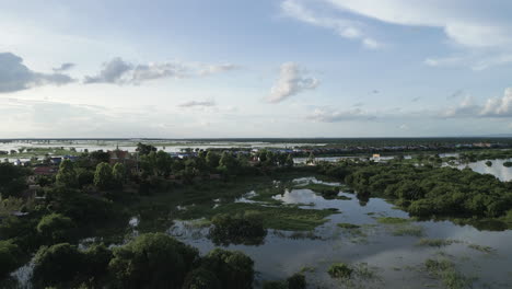 drone video captures a traditional gateway standing on a hilltop, overlooking green wetlands and distant tonlé sap lake