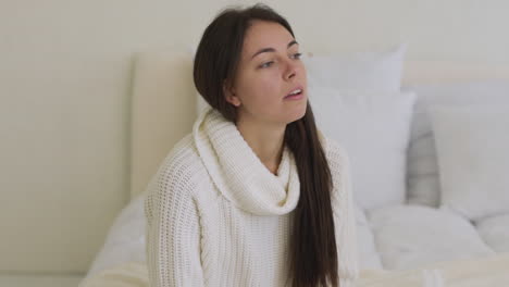 sick woman coughing sitting in bed at home alone 1