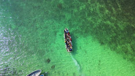 Von-Oben-Gesehen-Ein-Boot-Voller-Menschen,-Die-Den-Strand-In-São-Tomé,-Afrika-Verlassen