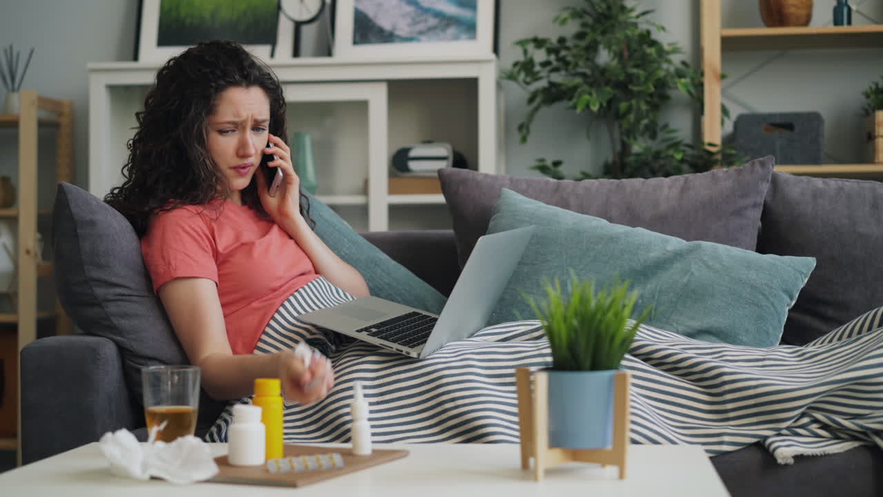 Kvinde syg på sofaen, videosamtale med læge