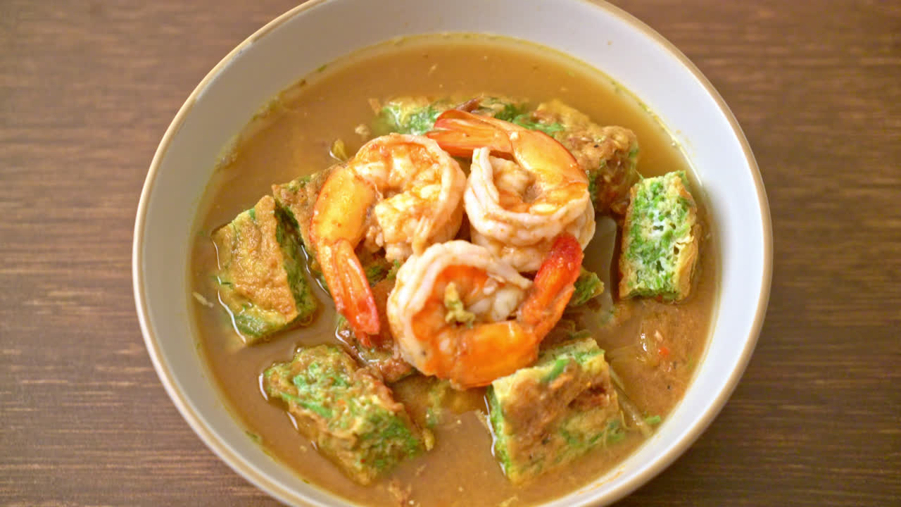 sopa agria hecha de pasta de tamarindo con gambas y tortilla de verduras - estilo de comida asiática
