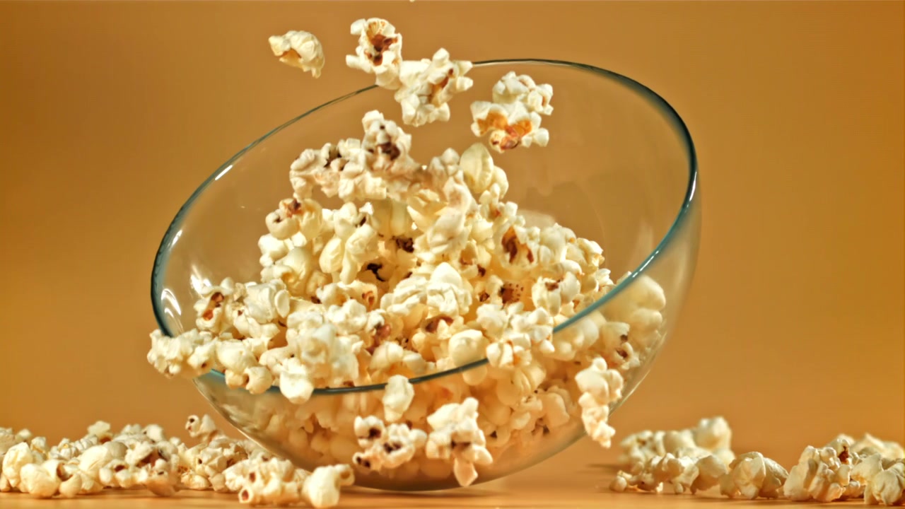 Popcorn che riempiono una ciotola di vetro al rallentatore
