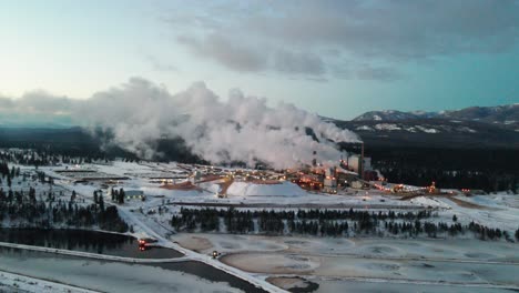 cold morning at pulp mill in cranbrook, british columbia: aerial view of industrial facility and specialized machinery processing raw materials for paper production