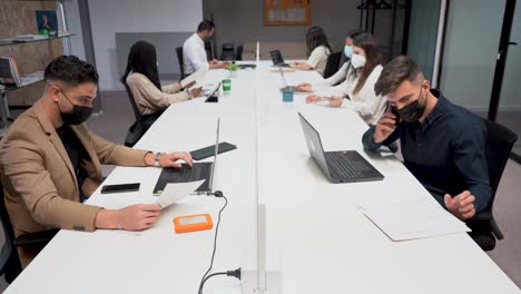 grupo de colegas sentados a la mesa en la oficina y trabajando